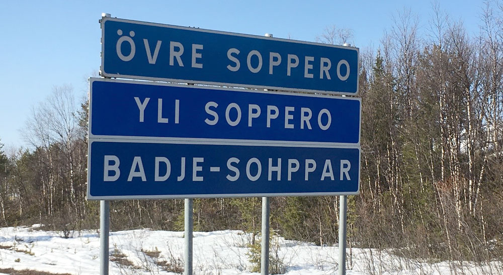 Vägverkets blåa vägskylt med det svenska namnet Övre Soppero, det meänkieliska Yli Soppero och det nordsamiska Badje-Sohppar.