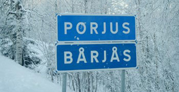 Trafikverkets blåa vägskylt med det svenska namnet Porjus och det lulesamiska Bårjås.