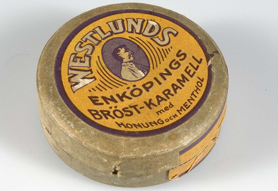 Fotografi föreställande en rund, äldre burk med halstabletter med smak av honung och menthol.