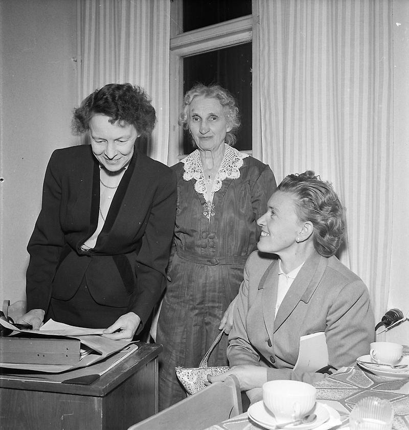 Tre kvinnor vid ett skrivbord.