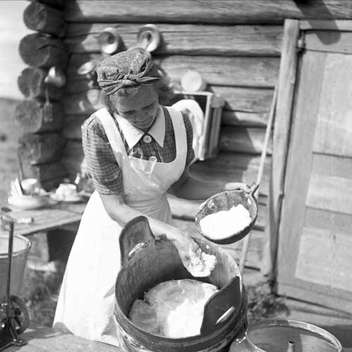 Kvinna strör salt över en massa i en spann.