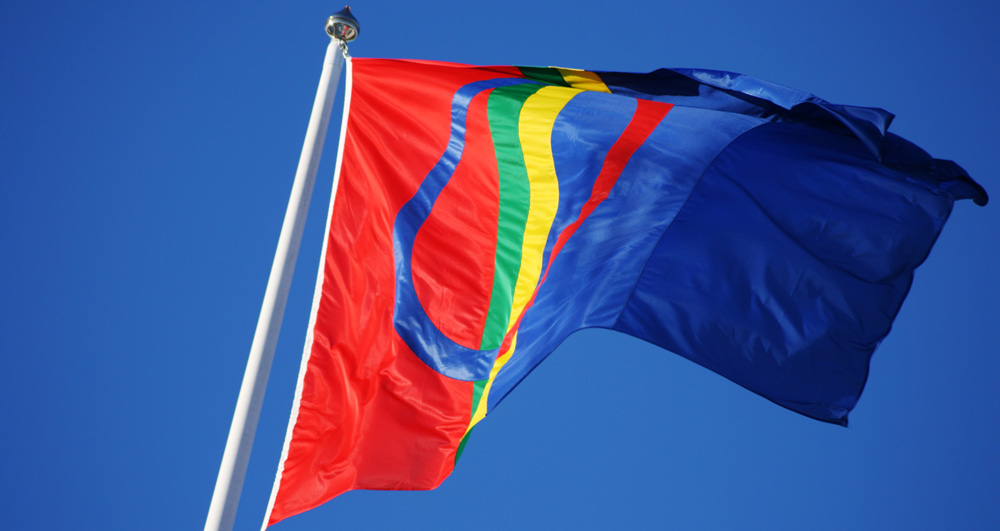 samisk flagga som fladdrar mot blå himmel