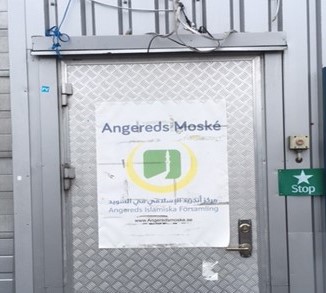 Bilden visar dörren till Angereds moské där skylten utgörs av en uppklistrad pappersaffisch med det svenska namnet skrivet överst och det arabiska längre ner i mindre stil.