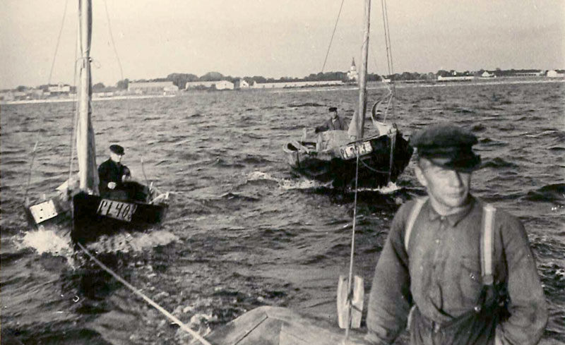 Svartvitt fotografi: män i båt.