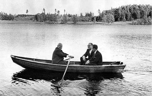Tre män i en eka på sjön.