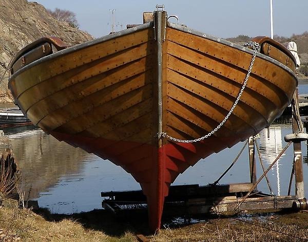 Open wooden boat in the water.