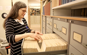 Kristina Hagren bläddrar igenom arkivkort med dialektord från folkmålen i övre Dalarna