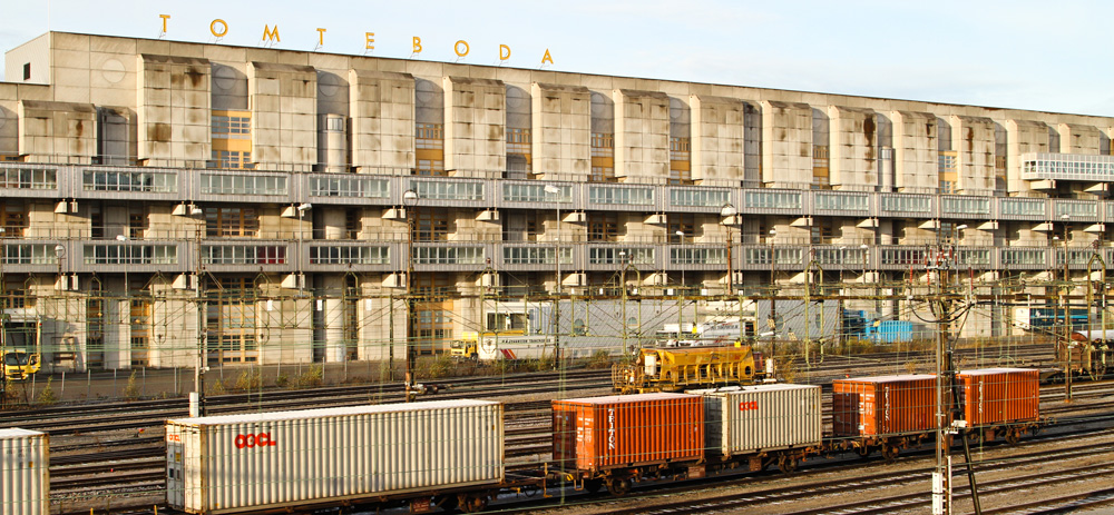Bild av grå byggnad med "Tomteboda" i stora gula bokstäver på taket.