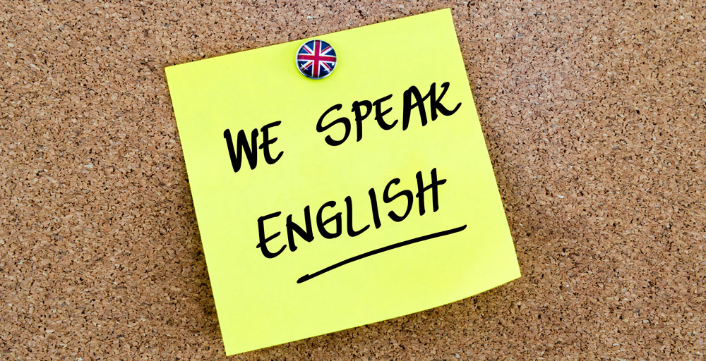 Postit-lapp med texten "We speak english". 