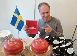 Huvudredaktören Ola Karlsson visar upp den nya Svenska skrivregler under ett boksläppsfirande på Språkrådet.