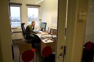 En man sitter framför en dator vid ett skrivbord