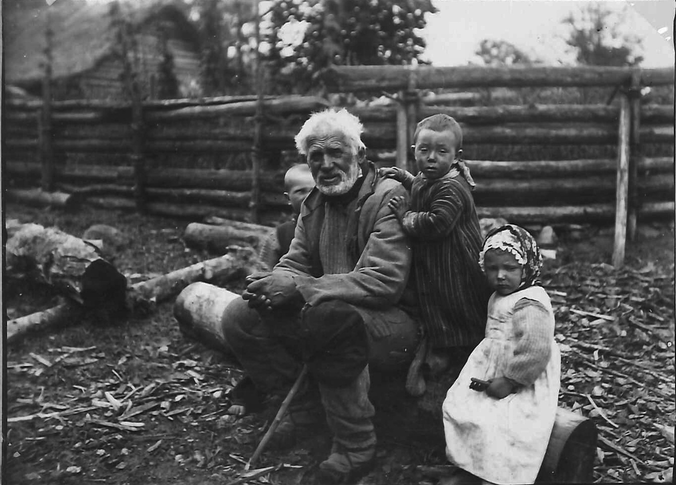 En äldre man omgiven av små barn.