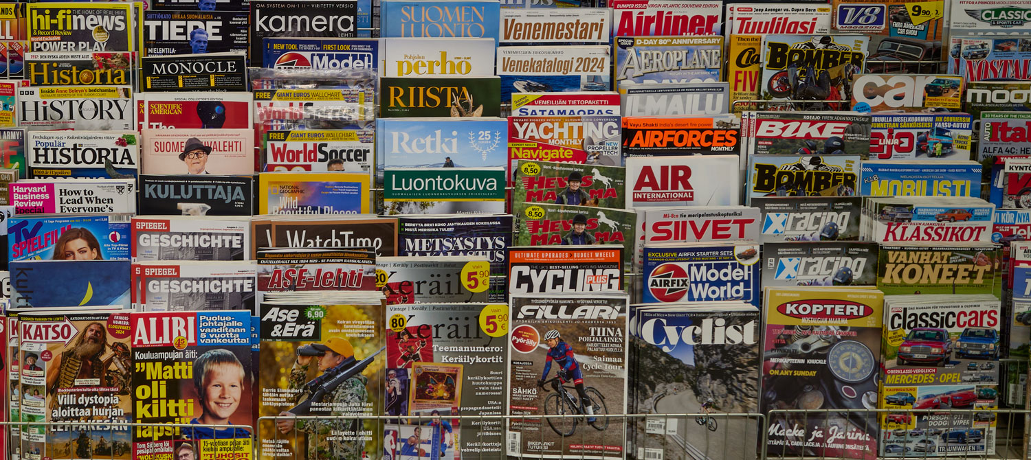 Tidningshylla med olika magasin på finska, svenska och engelska.